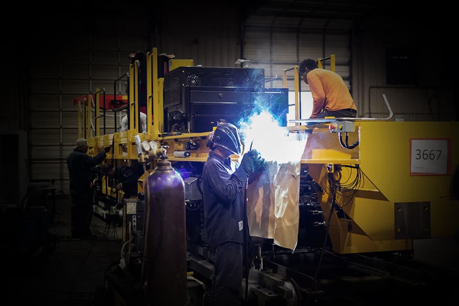A Tidewater Tech graduate working at Plasser American, welding in their machine shop.
