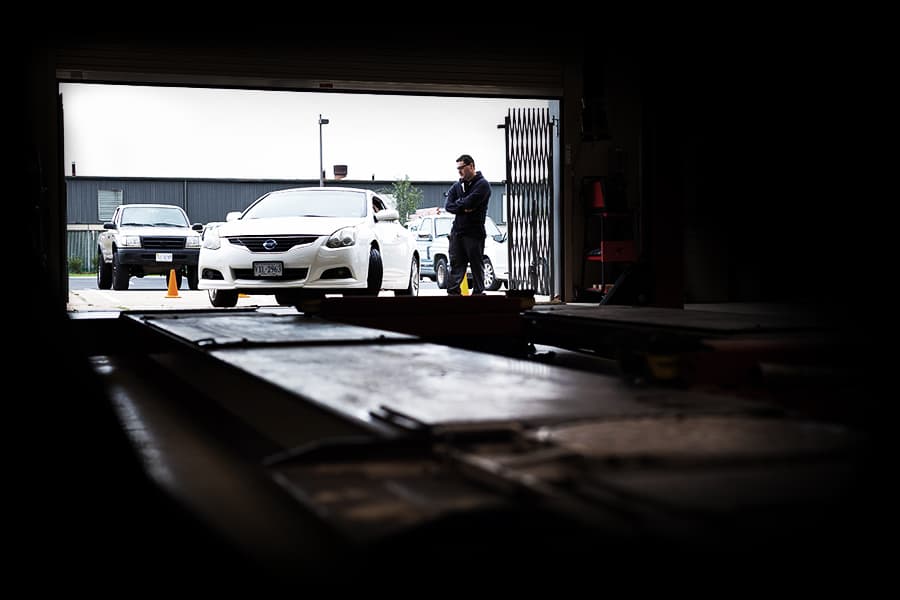 Automotive Technician stands in an open garage