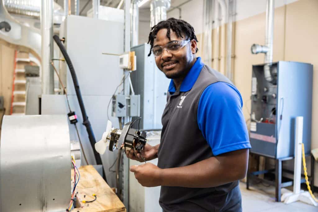 HVAC training student working on a fan motor assembly during hands-on instruction at Tidewater Tech in Norfolk, VA.