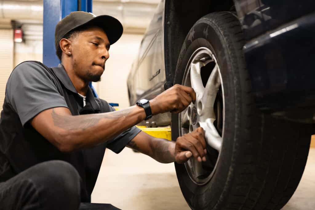 Car mechanic working on a wheel of a car