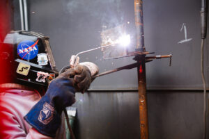 A student spot welding in class